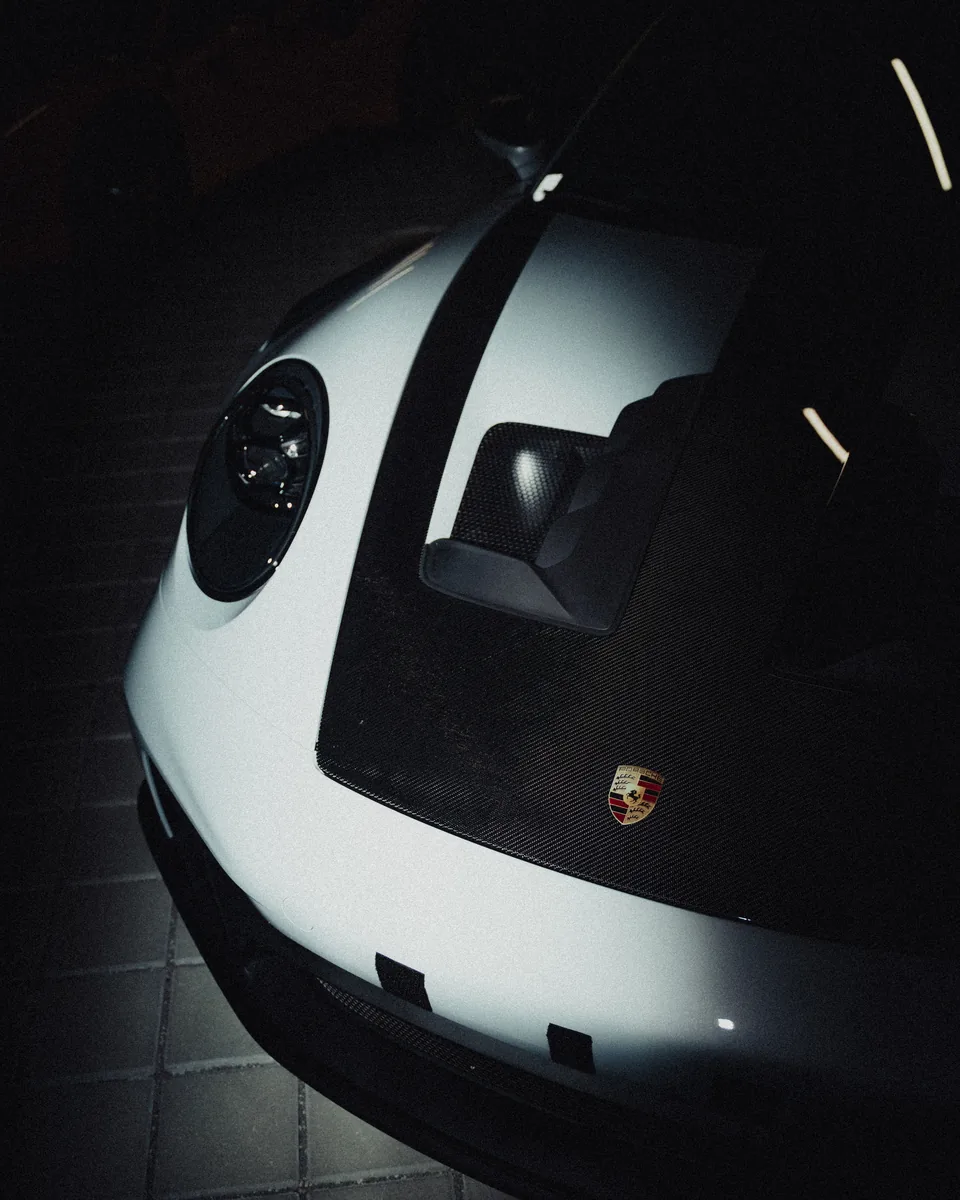 Porsche-Emblem und geöffnete Fronthaube