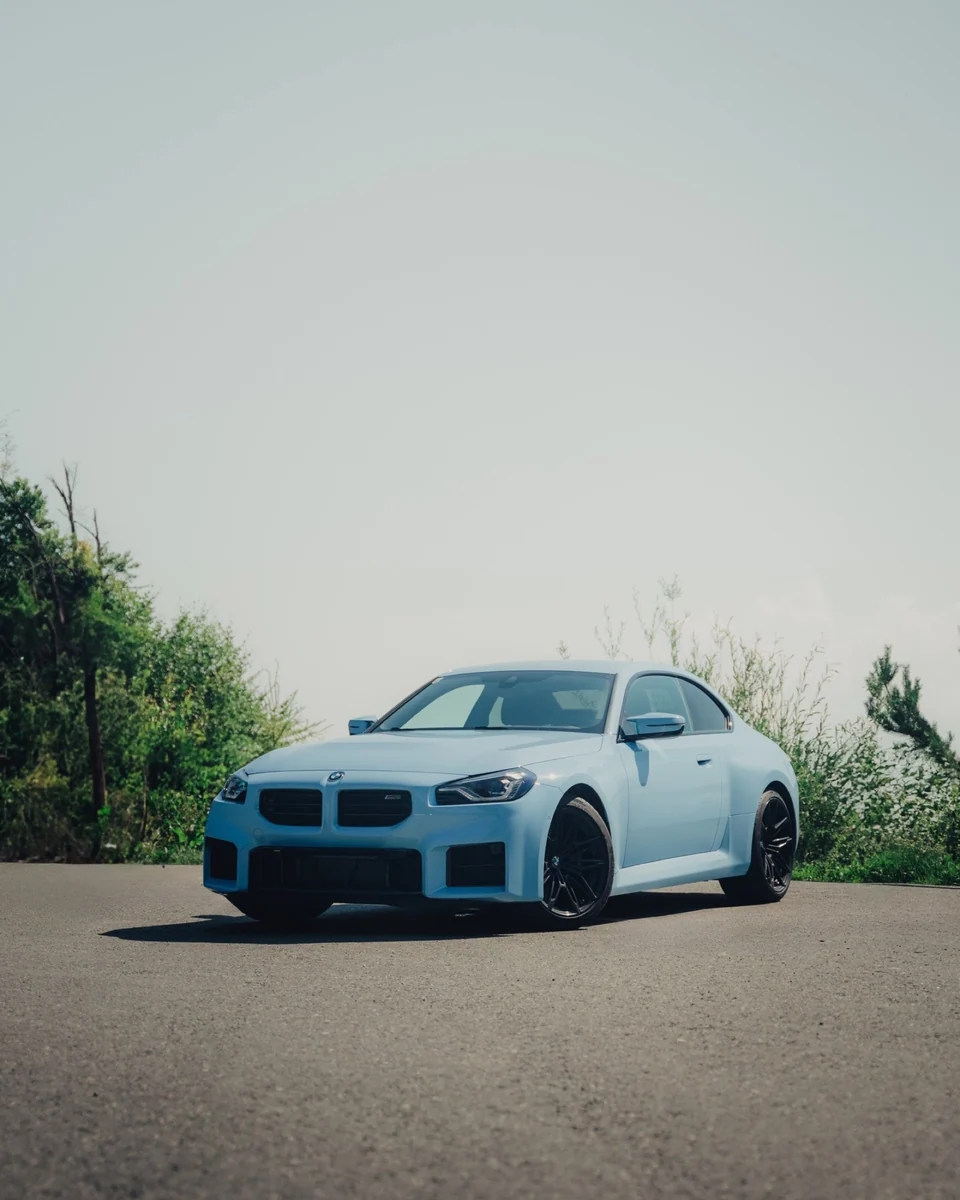 Weißer BMW M2 frontal mit viel hellem Himmel